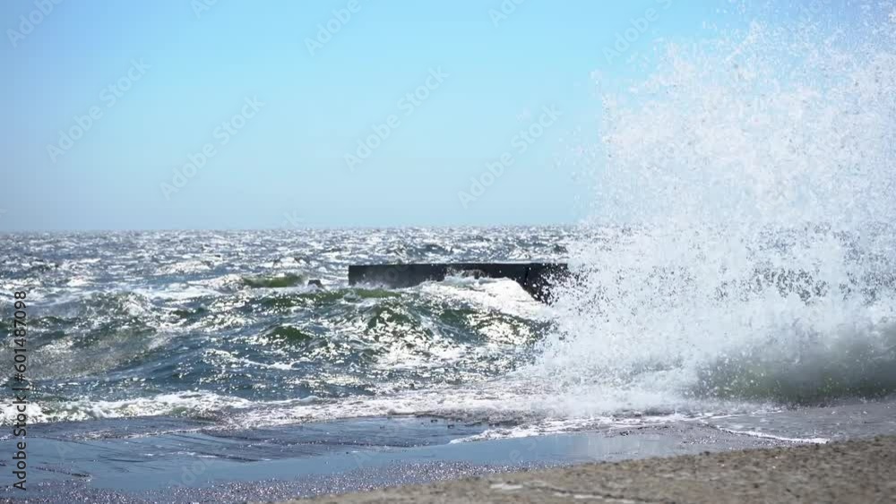 Sea waves beat on stony shore on the embankment