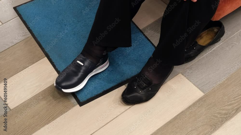 Elderly woman trying on new sports shoes. Legs top view close-up Elderly woman trying on new sports shoes. Legs top view close-up