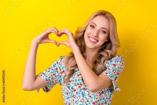 Portrait of cheerful stunning cute kind lady dressed stylish clothes two arms make heart symbol isolated on yellow color background