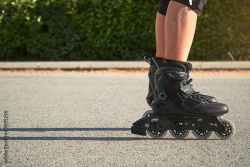 Teenage girl skating wih rollerskates in the street in summer. Skating is low-impact exercise that provides an excellent cardiovascular workout and reduces the risk of osteoporosis