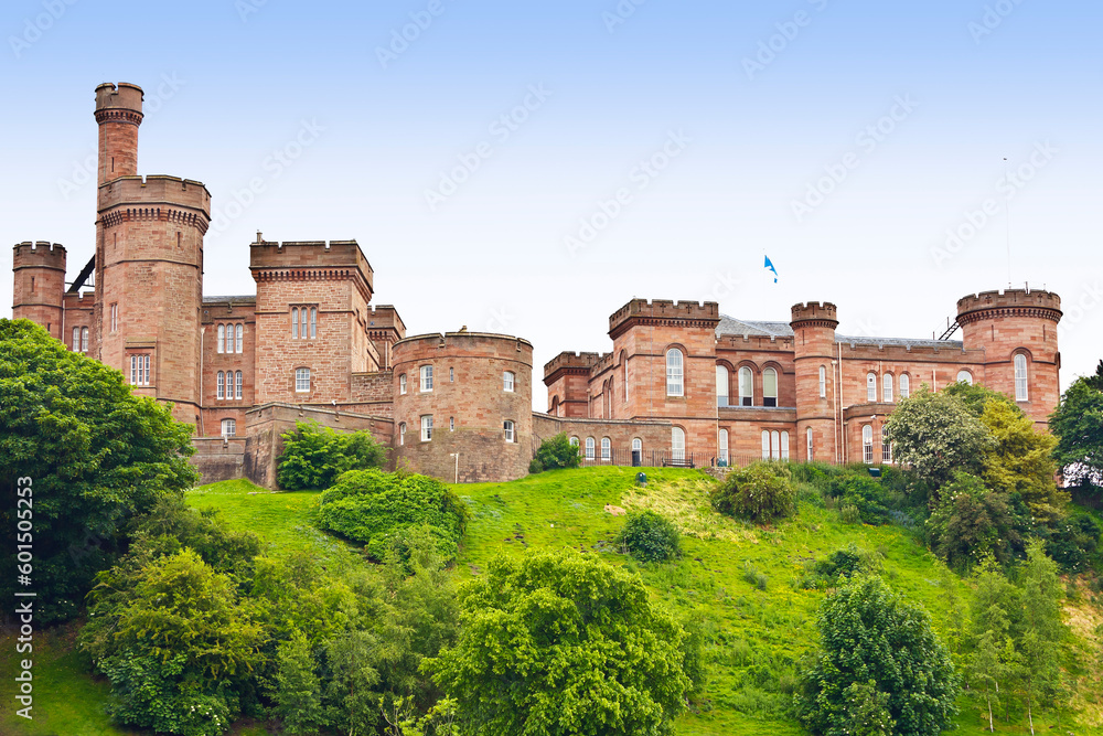 Old Inverness Castle built of red sandstone on a green hill in summer as seen from the river Ness. Scotland, Great Britain, Europe.