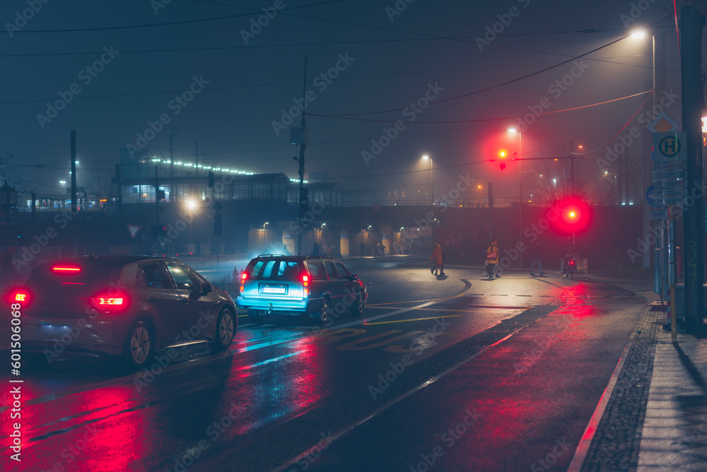 Cars standing at a traffic light in foggy wet weather