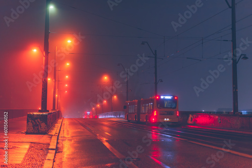 Traffic on a foggy wet bridge, a brightly lit bridge in foggy weather