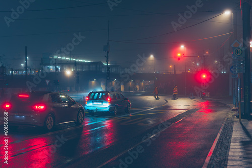 Cars standing at a traffic light in foggy wet weather