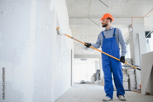 Painter in uniform paints the wall.