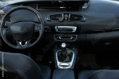 Car interior details adjustments. Inside car interior with front seats, driver and passenger, textile, windows, console, manual gear shift, electric buttons, digital speedometer © uflypro