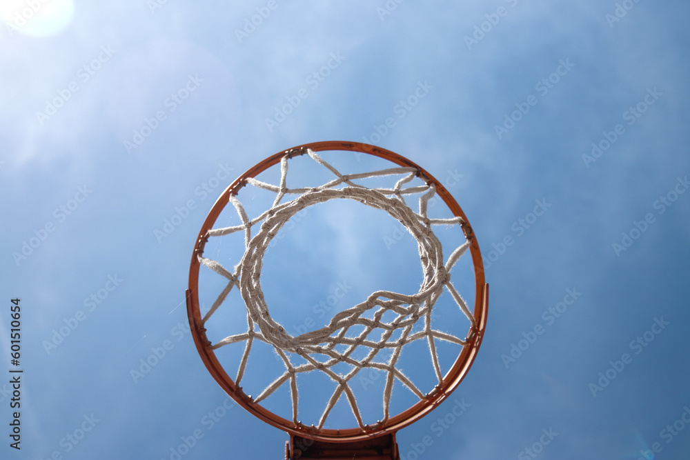 Outdoor neighborhood basketball court park and recreational area, Basketball net and backboard against sunny blue sky with copy space Outdoor neighborhood basketball court park and recreational area, Basketball net and backboard against sunny blue sky with copy space