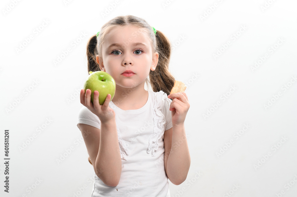 A little girl is holding one apple and chips on a white background. A little girl is holding one apple and chips on a white background.