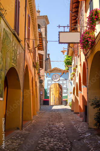 Old street of Dozza with street art and arc with clocks