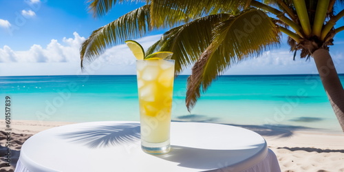 A yellow cocktail in a glass on a white table against the background of a sea beach on a bright sunny day under palm trees. Generative AI. © Sergiy