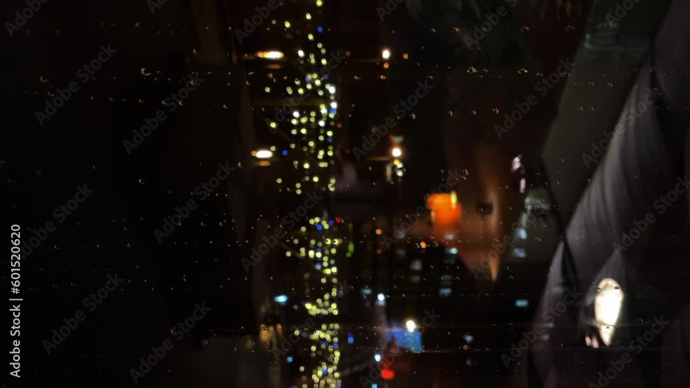 raindrops run down the glass, against the background of the city, at night raindrops run down the glass, against the background of the city, at night