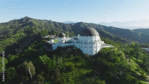 Scenic aerial world famous Griffith Observatory with green lawn and observation deck tourist attraction in Los Angeles city with amazing downtown views at summer. Los Angeles California USA Mar 2023