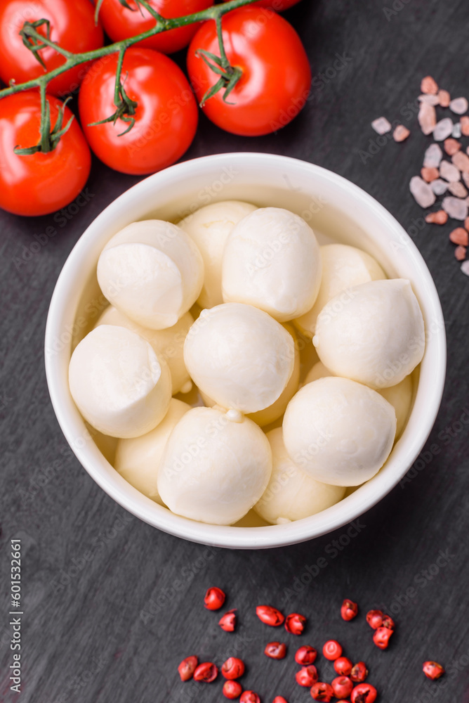 Delicious fresh mozzarella cheese in the form of small balls with salt and spices Delicious fresh mozzarella cheese in the form of small balls with salt and spices