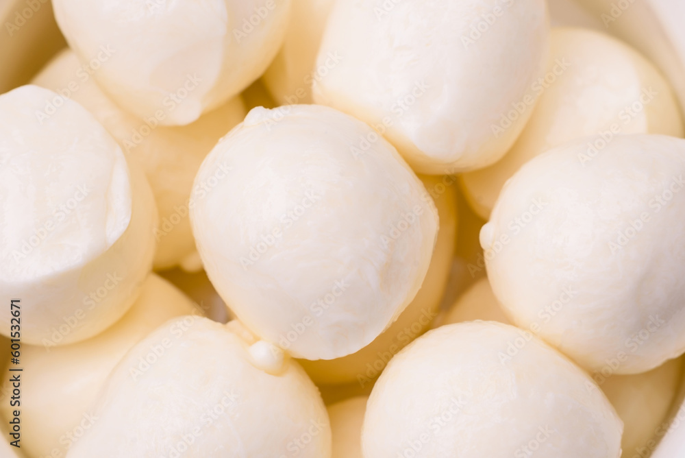 Delicious fresh mozzarella cheese in the form of small balls with salt and spices Delicious fresh mozzarella cheese in the form of small balls with salt and spices