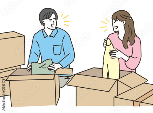 段ボール箱の前で荷造りする男女のカップル
