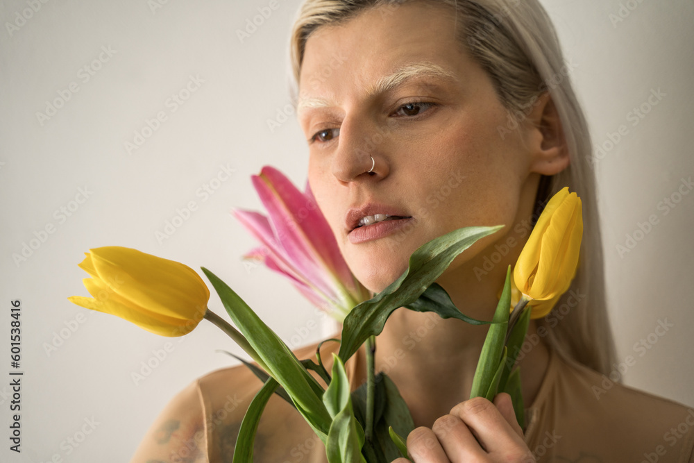 Caucasian girl holding tulip flowers and looking away Caucasian girl holding tulip flowers and looking away