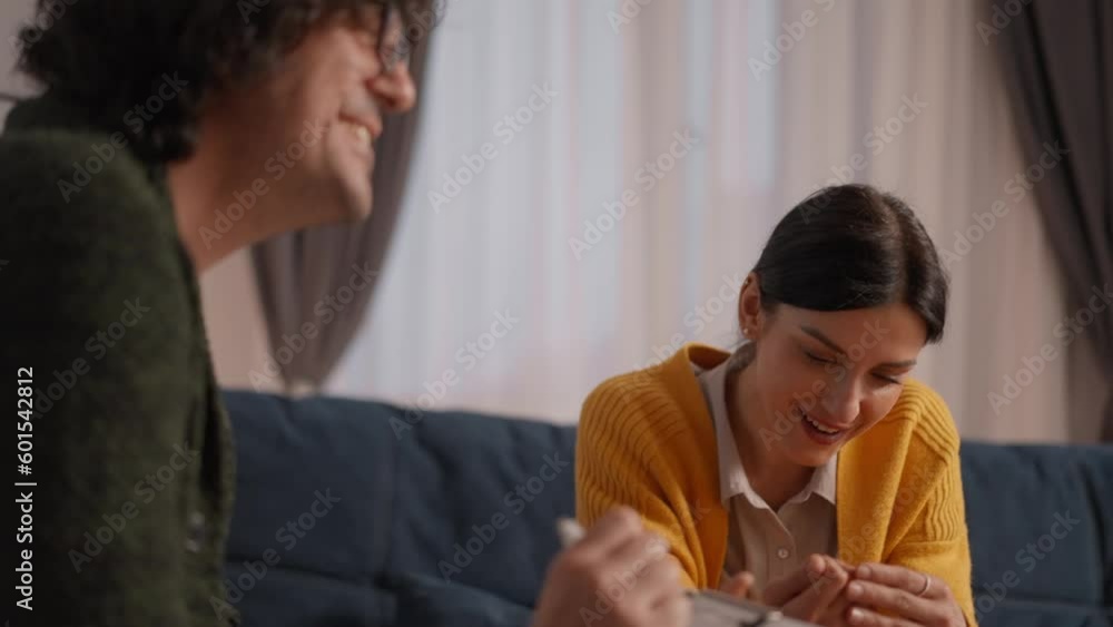 Happy young casual woman smiles and luaghs looking at her counselor while listening to his advice during individual session Happy young casual woman smiles and luaghs looking at her counselor while listening to his advice during individual session