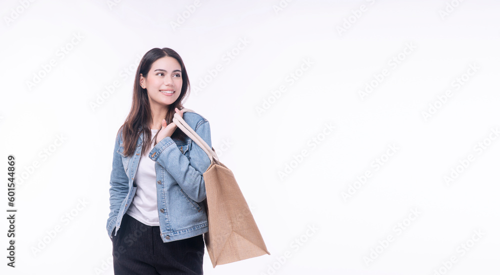 Cheerful shopper asian mixed race women holding tote eco handbag looking copy space on isolated white background. Beautiful happy young girl wear jacket jeans holding cotton cloth handbag for shopping Cheerful shopper asian mixed race women holding tote eco handbag looking copy space on isolated white background. Beautiful happy young girl wear jacket jeans holding cotton cloth handbag for shopping