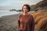 Portrait of a beautiful mature woman standing on the beach at sunset