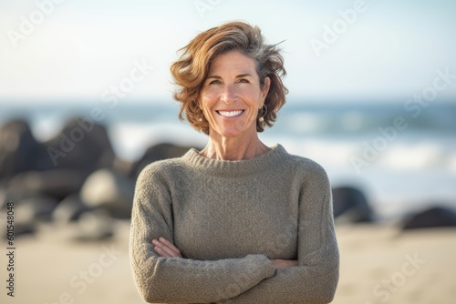Portrait of smiling woman with arms crossed on the beach at the day time © Hanne Bauer