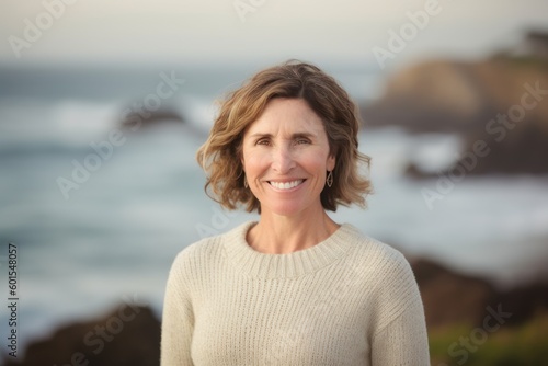 Portrait of smiling mature woman on the beach at the day time © Hanne Bauer