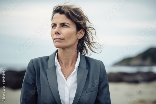 Portrait of a mature businesswoman in a suit on the beach © Hanne Bauer