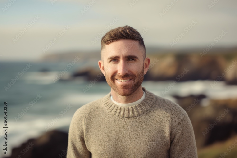 Portrait of handsome man smiling at camera while standing on the beach Portrait of handsome man smiling at camera while standing on the beach