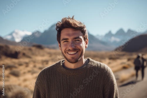 Portrait of handsome man smiling at camera in the mountains on a sunny day