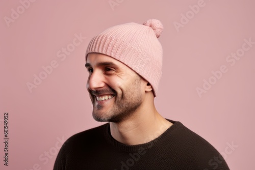 Portrait of a smiling young man in a pink hat on a pink background