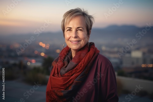 Portrait of smiling senior woman with red scarf against view of the city