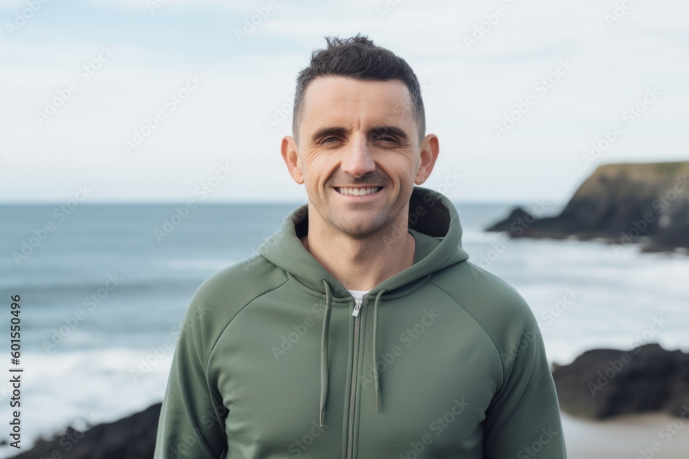 Portrait of handsome man smiling at camera while standing on seashore Portrait of handsome man smiling at camera while standing on seashore