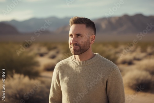 Portrait of a handsome man standing in the middle of the desert