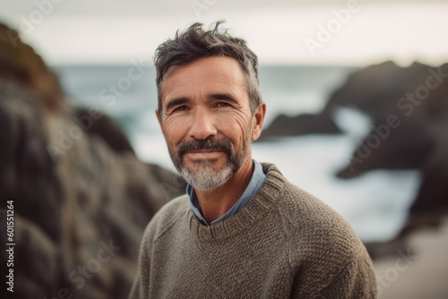 Portrait of mature man looking at camera on the beach at sunset