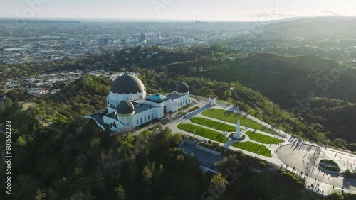 Impressive aerial view of the Griffith Observatory Entrance lawn observation deck. Green park on Mount Hollywood on sunny summer sunset under blue sky. Los Angeles cityscape California USA March 2023
