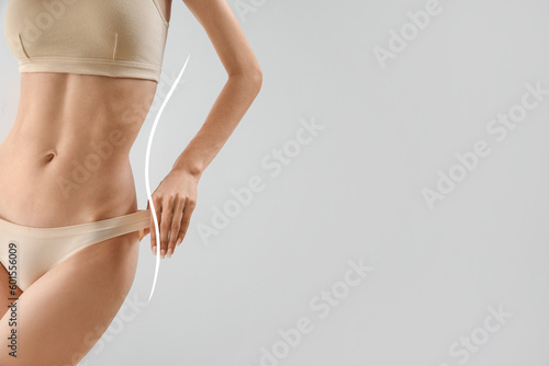 Slim young woman in underwear on light background with space for text. Diet concept