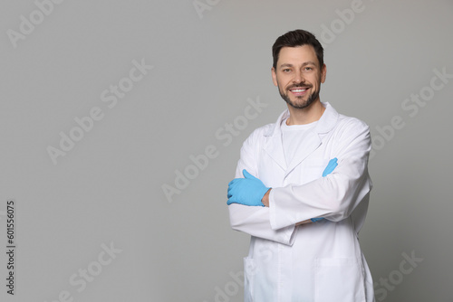 Doctor or medical assistant (male nurse) in uniform on light grey background. Space for text photo