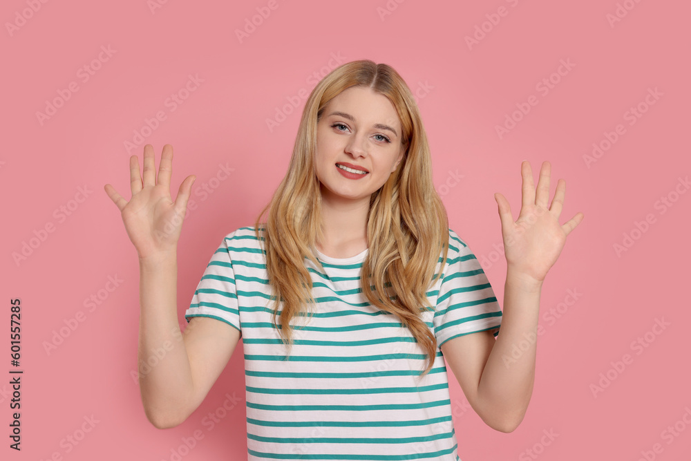 Happy woman giving high five with both hands on pink background Happy woman giving high five with both hands on pink background