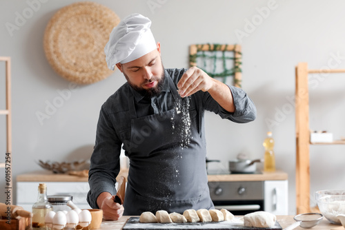 Male baker sprinkling cut d...
