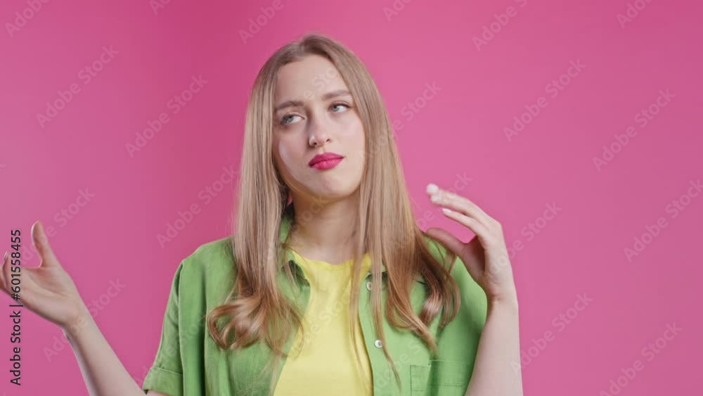 Irritated woman showing bla-bla gesture with hands on pink background. Irritated woman showing bla-bla gesture with hands on pink background.