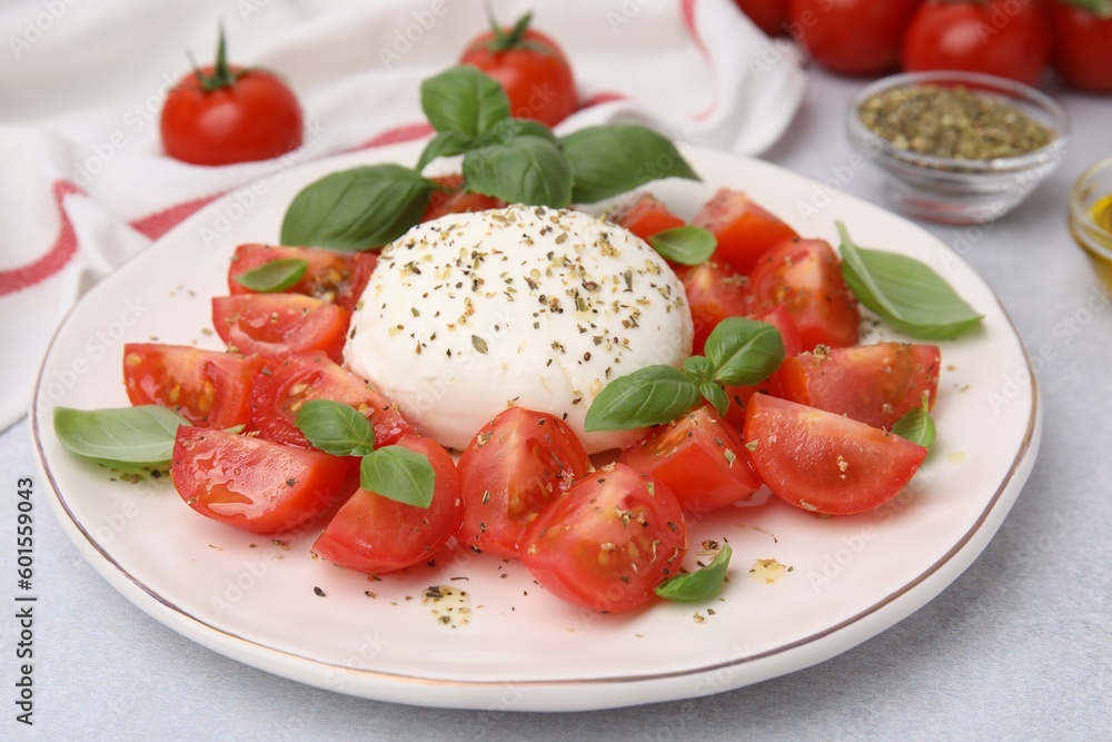 Tasty salad Caprese with mozarella, tomatoes and basil on light table, closeup Tasty salad Caprese with mozarella, tomatoes and basil on light table, closeup