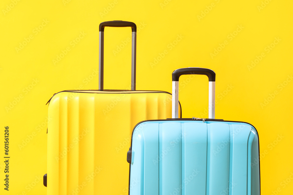 Big suitcases on yellow background, closeup Big suitcases on yellow background, closeup