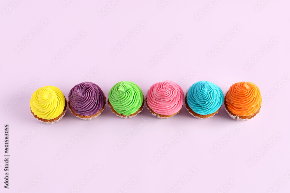 Tasty colorful cupcakes on purple background Tasty colorful cupcakes on purple background