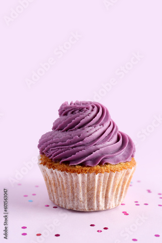 Tasty cupcake on purple background