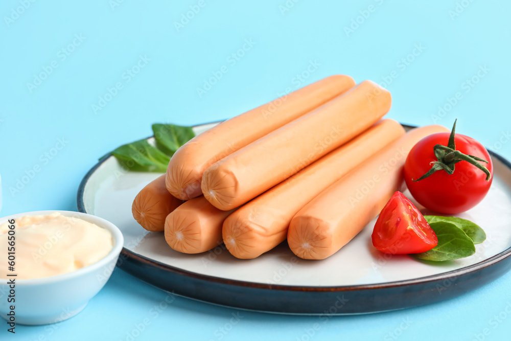 Plate of tasty sausages on blue background Plate of tasty sausages on blue background