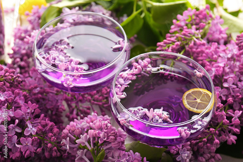 Composition with glasses of cocktail and beautiful lilac flowers  closeup