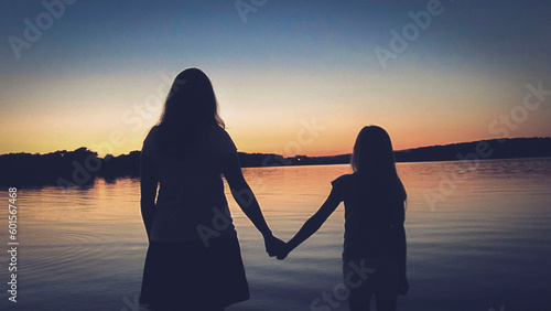 Fototapeta Naklejka Na Ścianę i Meble -  Mother and daughter enjoying the wonderful view in a beautiful sunset on Mother's Day