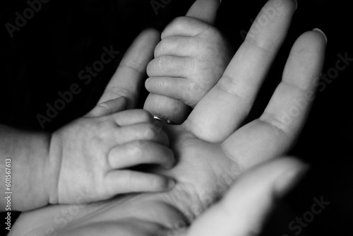 Foto Baby holding her mother's hand with her little hands in a sweet and innocent way