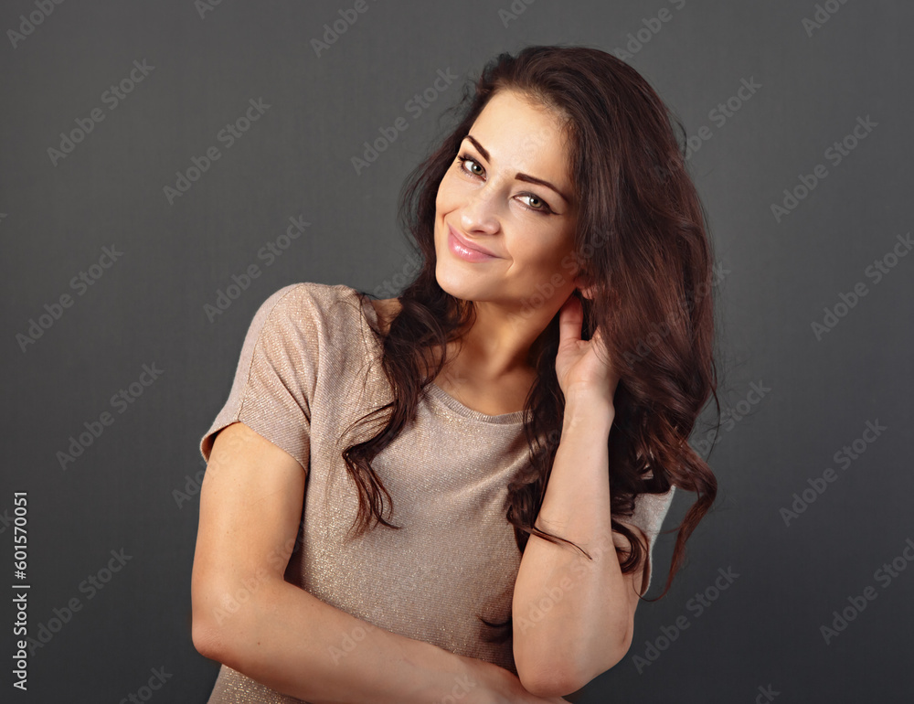 Fototapeta premium Beautiful makeup toothy enjoying smiling woman with long brown healthy curly hair style in fashion shirt clothing. Closeup studio portrait on grey