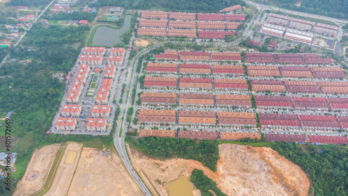 Aerial view of residential area with green asphalt road and residential houses directly above viewpoint. View of suburbs and city district. Real estate and housing market concept.