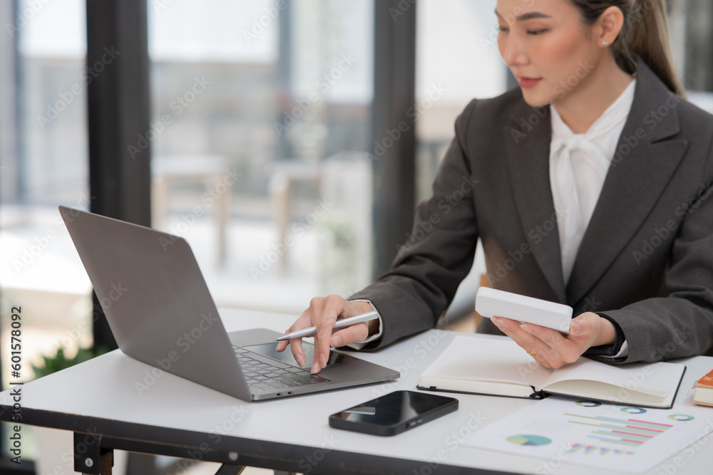 Young Asian businesswoman working on documents at office Young Asian businesswoman working on documents at office
